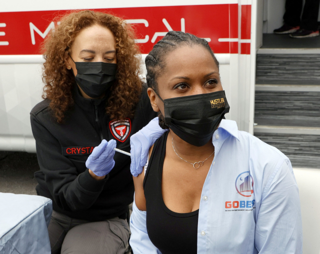 21일 미국 네바다 주 라스베거스에 있는 래리 플린트 코로나19 예방접종 클리닉에서 간호사가 GoBEST 부사장 아디아 포스터에게 모더나 백신을 접종하고 있다./AFP연합뉴스