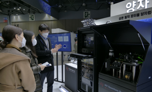 정호중(오른쪽) KIST 선임연구원이 22일 경기 고양시 킨텍스에서 열린 ‘2021 대한민국 과학기술대전’에서 참석자들에게 양자기술에 관해 설명하고 있다.