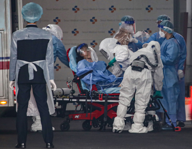 서울의 한 병원에서 방호복을 입은 의료진들이 환자를 이송하고 있다. /연합뉴스
