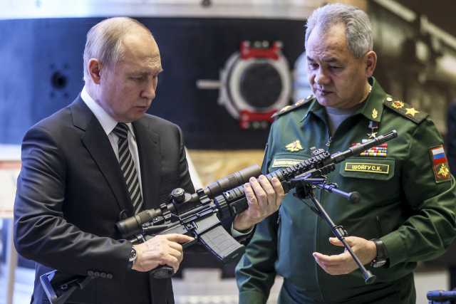 블라디미르 푸틴(왼쪽) 러시아 대통령이 21일(현지 시간) 수도 모스크바에서 열린 한 군용품 전시회를 방문해 총기를 살펴보고 있다. /AP연합뉴스