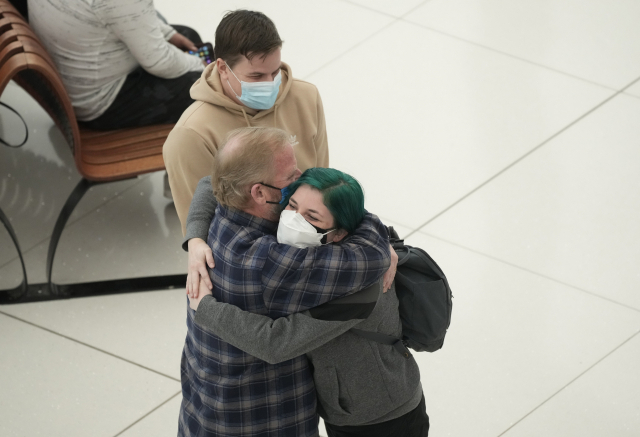 24일(현지시간) 미국 덴버 국제공항에서 한 여행객이 가족을 만나 포옹하고 있다./AP연합뉴스