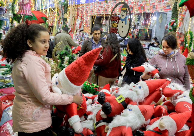 24일(현지시간) 이집트 카이로의 한 상점에서 여자 아이가 산타 클로스 인형을 고르고 있다./연합뉴스