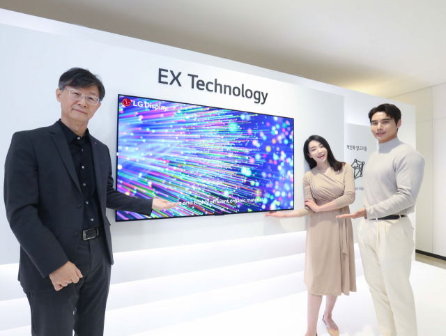 오창호(왼쪽) LG디스플레이 부사장이 모델들과 OLED.EX 패널 기술에 대해 소개하고 있다. /사진 제공=LG디스플레이