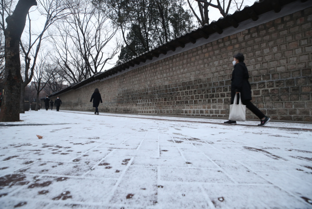 밤사이 눈이 내려 쌓인 29일 오전 시민들이 서울 중구 정동길을 걷고 있다. /연합뉴스