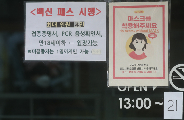 서울 시내의 한 식당에 31일 영업시간과 방역패스를 안내하는 문구가 붙어 있다. 정부는 이날 청소년 방역패스를 당초 계획보다 한 달 연기한 내년 3월부터 시행한다고 밝혔다. /연합뉴스