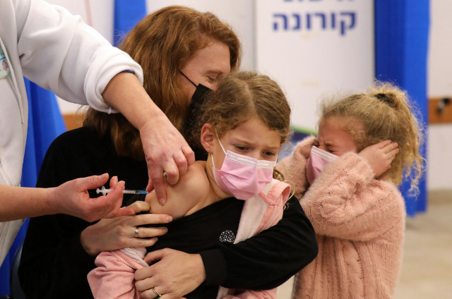 2일(현지 시간) 이스라엘에서 한 아이가 엄마의 품에 안겨 코로나19 백신을 접종하고 있다./AFP연합뉴스