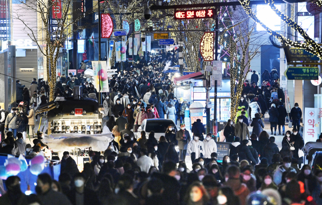 성탄절을 하루 앞둔 지난달 24일 서울 중구 명동거리에 사람들 사이로 한 차량이 지나고 있다. /서울경제DB