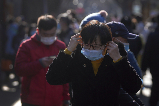 지난 2일 중국 베이징에서 한여성이 마스크를 쓰고 있다. /AP연합뉴스