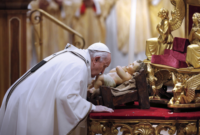 프란치스코 교황이 지난해 12월 24일(현지시간) 바티칸 성베드로 대성전에서 집전한 성탄 전야 미사에서 아기 예수상에 입맞춤하고 있다./사진=UPI 연합뉴스