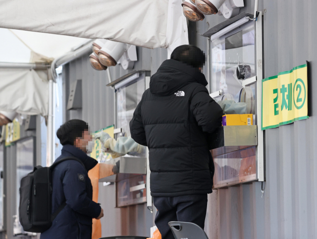 코로나19 선별진료소를 찾은 시민들이 검사를 받고 있다./연합뉴스