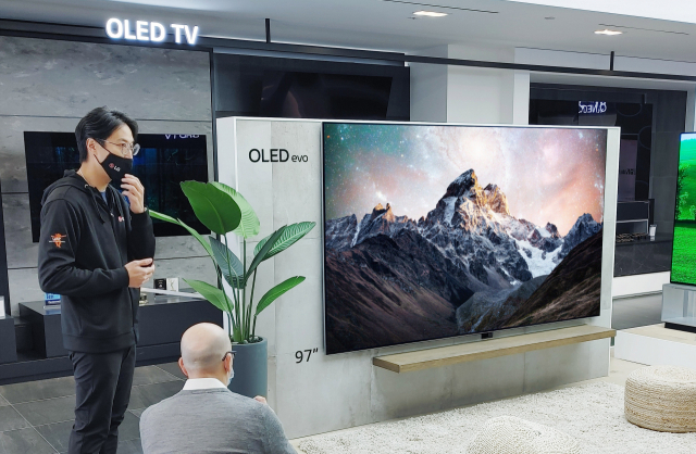 LG전자 미국법인 관계자(왼쪽)가 CES 2022 관객들에게 LG 올레드 TV를 소개하고 있다./사진 제공=LG전자