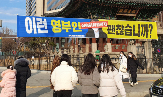 서울 주요 도심 곳곳에 윤석열 국민의힘 대선후보 부인 김건희 씨를 겨냥한 현수막이 내걸려 구청이 수거에 나섰다. 지난달 30일 종로구청 등에 따르면 진보성향 시민단체 개혁과전환 촛불행동연대는 전날 광화문과 서울시청 인근 등 서울 시내에 김씨 얼굴을 '상습 허위경력자'라는 문구로 가리고, '이런 영부인 괜찮습니까?'라는 내용이 담긴 현수막을 설치했다./연합뉴스