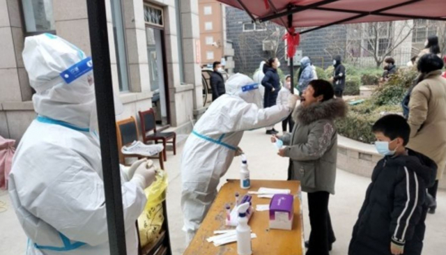 중국 허난성의 안양에 신종코로나바이러스감염증(코로나19) 봉쇄 조치가 내려진 가운데 12일 외출이 제한된 한 주택단지의 입주자들이 3차 핵산 검사를 받고 있다. /로이터연합뉴스
