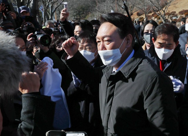 윤석열 국민의힘 대선 후보가 14일 오후 경남 창원시 마산회원구 국립 3·15 민주 묘지를 참배한 뒤 지지자들에게 대선 승리를 다짐하며 주먹을 쥐고 있다./창원=연합뉴스