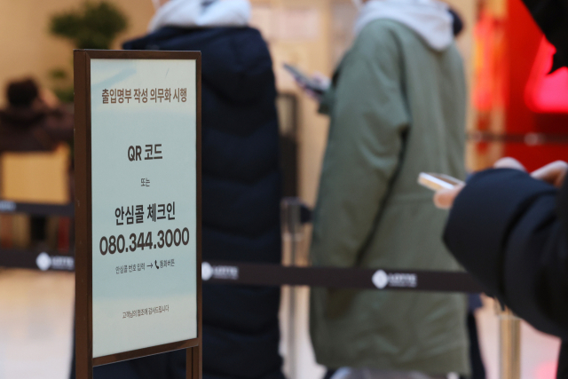 17일 서울의 한 백화점에서 시민들이 QR코드 또는 안심콜 체크인으로 출입 명부를 작성하고 있다./연합뉴스