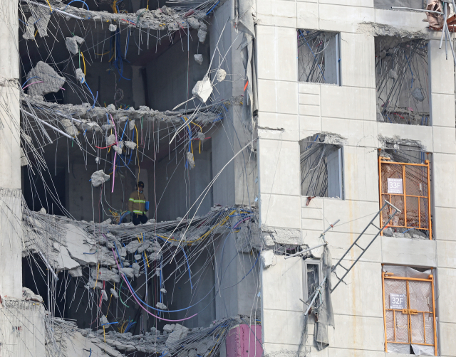 구조대원이 15일 오전 광주 붕괴 사고 현장을 살펴보고 있다. /연합뉴스