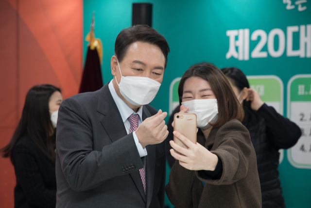 윤석열 국민의힘 대선 후보가 18일 서울 영등포구 사회복지사협회에서 간담회를 마치고 한 참석자의 셀카 촬영 요구에 응하고 있다./권욱 기자