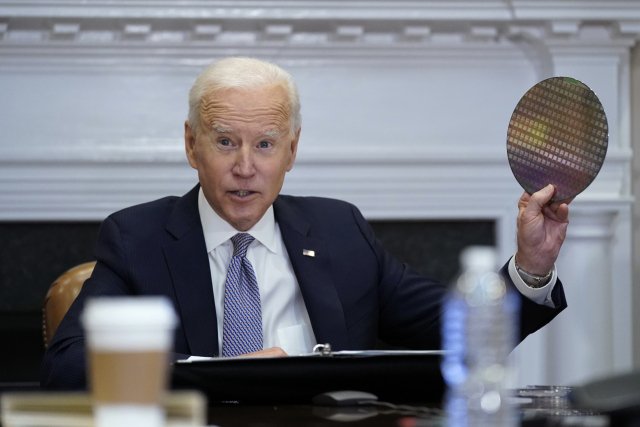 지난해 4월 백악관에서 열린 반도체 공급망 회의에서 조 바이든 대통령이 웨이퍼를 흔들고 있는 모습/연합뉴스