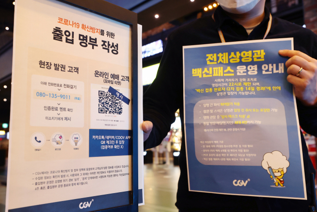 지난 18일 서울 용산구 CGV 용산아이파크몰점에서 직원이 방역패스 안내문을 교체하고 있다./연합뉴스