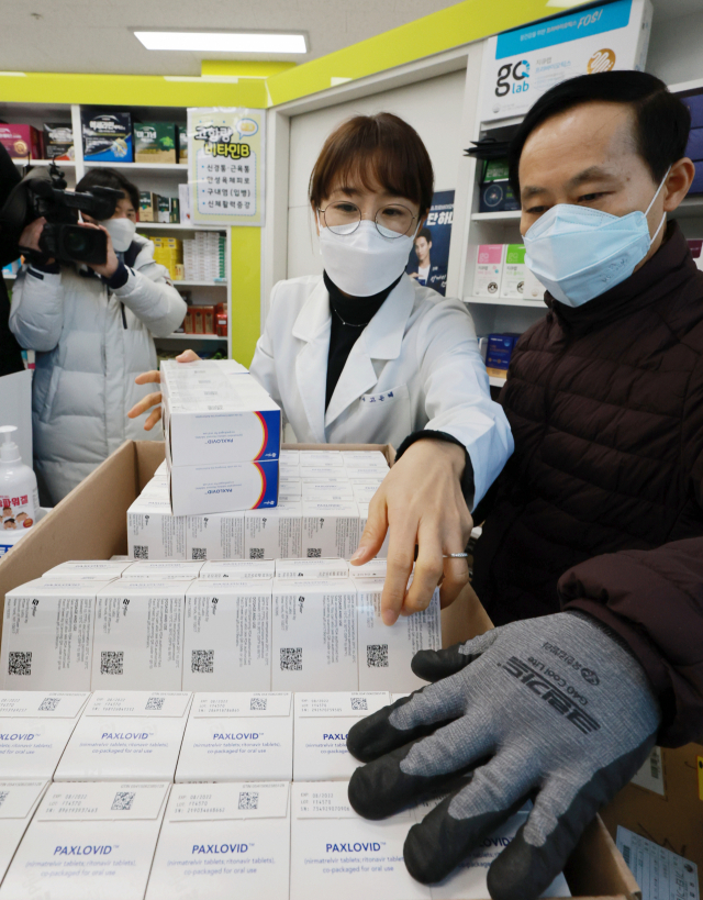 지난 14일 오전 서울 금천구의 한 약국에서 코로나19 먹는 치료제 팍스로비드가 입고돼 약사와 국내 유통사 관계자가 수량을 확인하고 있다./연합뉴스