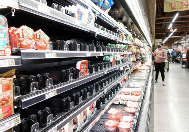 지난 13일 미국 버지니아에 있는 한 식료품점의 햄 제품 진열대가 부분적으로 비어 있다. 지난해부터 이어진 공급망 붕괴와 오미크론 확산, 겨울 폭풍우 등의 영향으로 상품이 부족한 상황이다./AFP연합뉴스