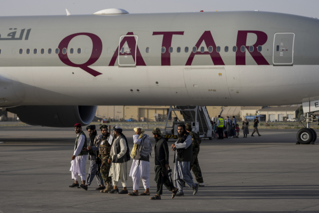 지난해 9월 아프가니스탄 수도 카불의 국제공항에 외국인을 대피하기 대기 중인 카타르항공 소속 여객기 곁을 탈레반 대원들이 걸어가고 있다./연합뉴스
