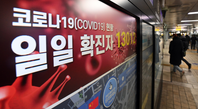 오미크론 변이가 급격히 확산하면서 신규 확진자가 처음으로 1만 명을 넘은 26일 서울 지하철 1호선 역사 내 전광판에 일일 코로나19 확진자 수 1만 3,012명이 표시돼 있다. /오승현 기자