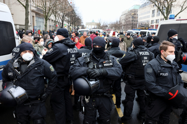독일 경찰이 26일(현지시간) 베를린에서 시위에 나선 백신 의무화 반대론자들과 대치하고 있다. /로이터연합뉴스