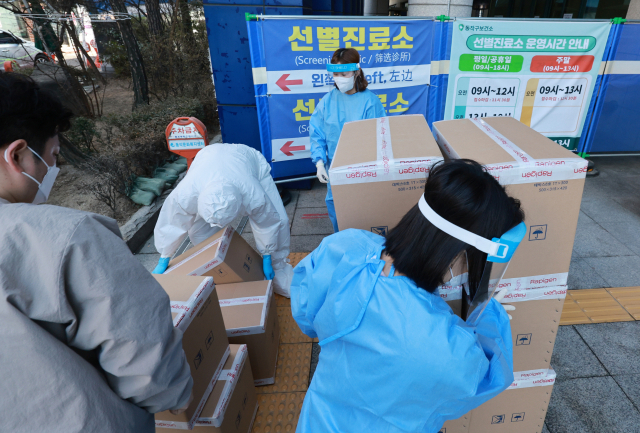 28일 서울 동작구 보건소 앞에서 관계자들이 코로나19 항원 자가진단키트를 보관 장소로 옮기고 있다./연합뉴스