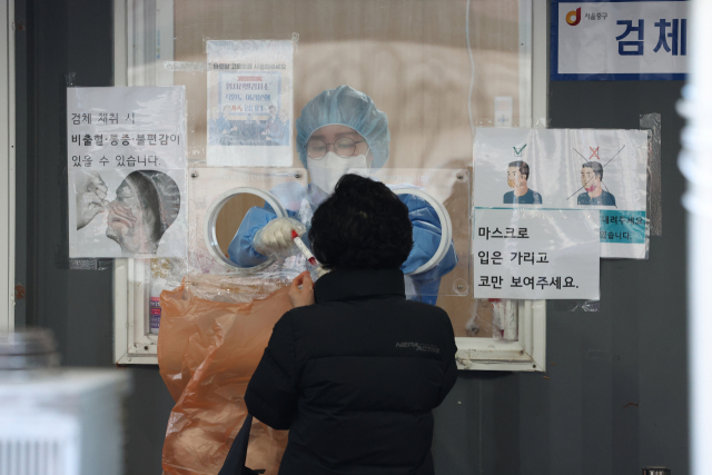 31일 오전 서울역광장에 마련된 코로나19 임시 선별검사소에서 의료진이 검체를 하고 있다./연합뉴스