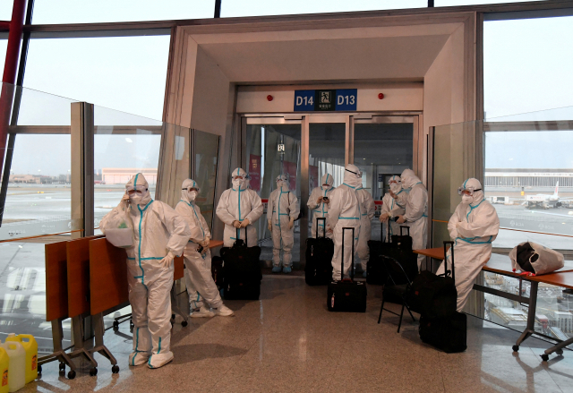 31일 중국 베이징수도국제공항에서 베이징 동계올림픽 스태프들이 방호복을 입은 채 입국 선수들을 맞을 준비를 하고 있다. /로이터연합뉴스