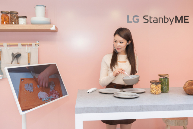 LG전자 모델이 주방에서 스탠바이미의 조리법 영상을 켜고 요리를 하는 모습을 시연하고 있다./사진 제공=LG전자