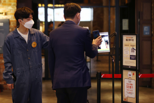 영화관, 대형마트 등에 대한 방역패스(접종증명·음성확인제) 적용이 해제된 지난달 18일 서울 용산구 CGV 용산아이파크몰점에서 고객이 입장 전 QR코드 체크를 하고 있다. /연합뉴스