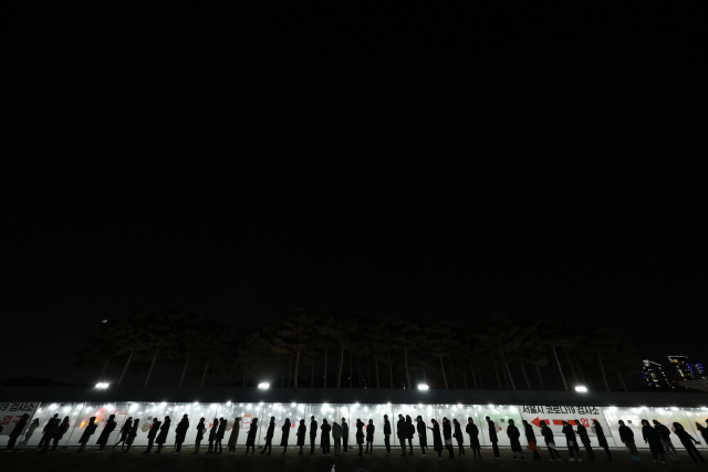 3일 오후 마포구 월드컵공원 평화광장에 마련된 코로나19 임시 선별검사소를 찾은 시민들이 신속항원검사를 받기 위해 줄을 서서 기다리고 있다./연합뉴스