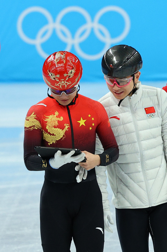 밝은 표정으로 중국 선수와 훈련 영상을 함께 확인하는 빅토르 안(오른쪽) 코치. /연합뉴스