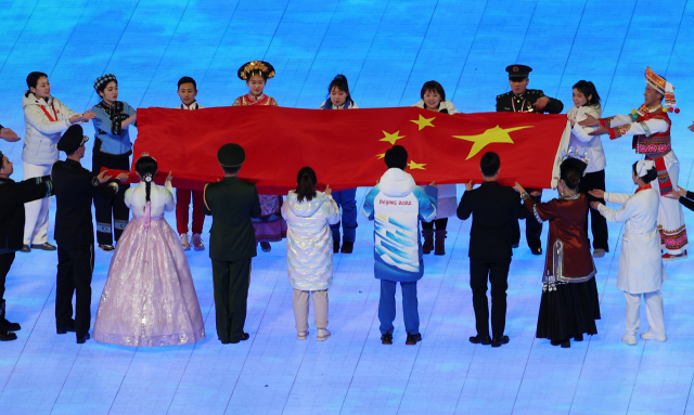 4일 오후 중국 베이징 국립경기장에서 열린 2022 베이징 동계올림픽 개회식에서 한복을 입은 한 공연자가 중국 내 56개 소수민족 대표 중 하나로 참여해 중국 국기인 오성홍기를 들고 있다. /연합뉴스