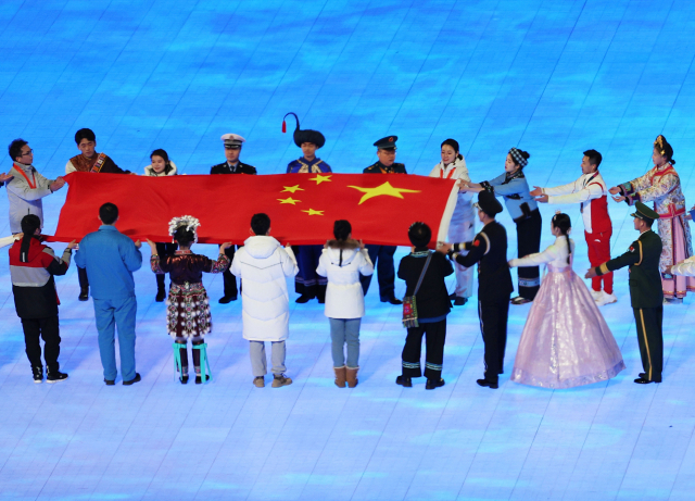 4일 오후 중국 베이징 국립경기장에서 열린 2022 베이징 동계올림픽 개회식에서 한복을 입은 한 공연자(앞줄 오른쪽에서 두 번째)가 중국 국기인 오성홍기 입장식에 참여하고 있다. /베이징=연합뉴스