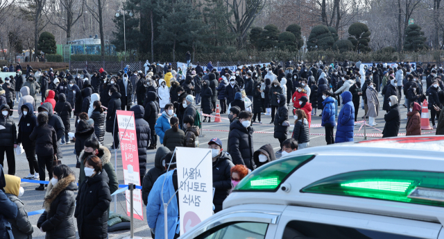 신종 코로나바이러스 감염증(코로나19) 누적 확진자가 100만명을 넘어선 6일 오후 송파구 잠실종합운동장 제2주차장 선별진료소에서 시민들이 검사를 위해 줄을 서있다. /연합뉴스