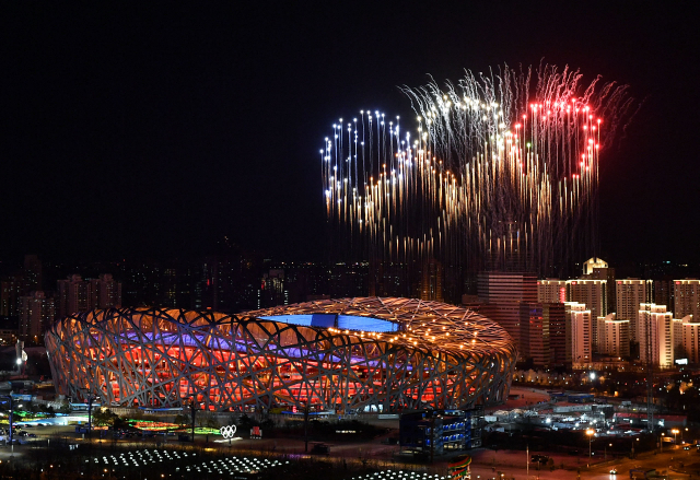 지난 4일 2022 베이징 동계올림픽 개막식이 한창인 가운데 베이징올림픽주경기장 위로 폭죽이 오륜기 모양을 그리고 있다. 베이징=AFP연합뉴스