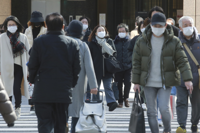 오미크론 변이가 급속히 번지고 있는 일본의 수도 도쿄에서 7일 마스크를 쓴 시민들이 길을 걷고 있다. AP연합뉴스