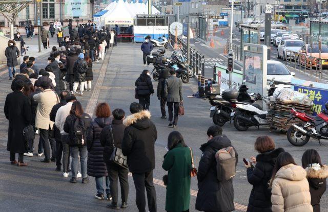 8일 오전 서울역광장에 마련된 코로나19 임시 선별검사소에 시민들이 검사를 받기 위해 줄을 서서 기다리고 있다.연합뉴스