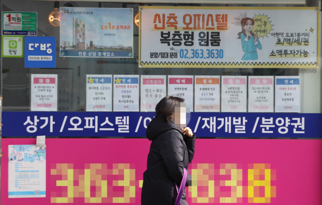 한 시민이 서울 시내 공인 중개 사무소 앞을 지나가고 있다. /연합뉴스