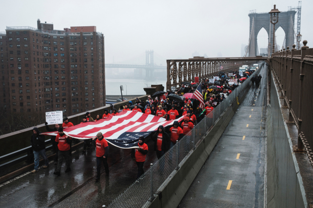 7일(현지 시간) 백신 의무화에 반대하는 시위대가 성조기를 들고 미국 뉴욕 브루클린 다리를 건너고 있다. 로이터연합뉴스
