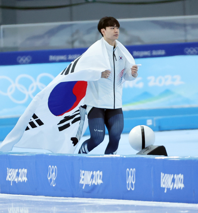 김민석이 빙속 남자 1500m 동메달이 확정된 뒤 태극기를 등에 두르고 세리머니 하고 있다. 연합뉴스
