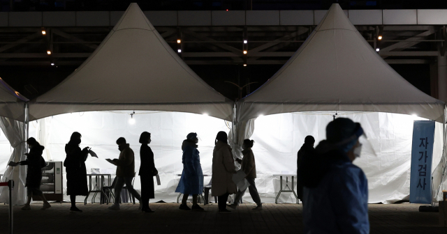 지난 8일 오후 서울 마포구 월드컵공원 평화광장에 마련된 코로나19 임시 선별검사소를 찾은 시민들이 신속항원검사를 받기 위해 줄을 서고 있다.연합뉴스