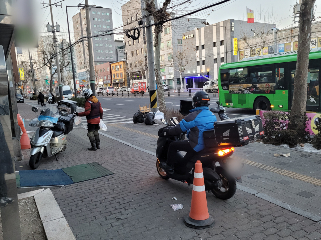 서울 은평구 학원가에 입점한 물류 창고에서 물품을 실은 오토바이가 인도를 달리고 있다. /강도림 기자