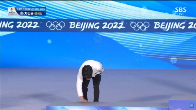 베이징 동계올림픽 스피드스케이팅 남자 500ｍ 은메달리스트 차민규가 지난 12일 시상대에 오르기 전 시상대를 손으로 쓰는 듯한 행동을 하고 있다. /올림픽 트위터