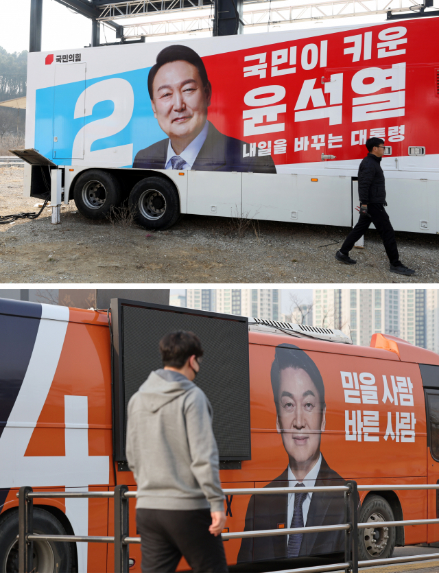 안철수 국민의당 대선 후보가 13일 국민의힘 윤석열 후보에게 야권 후보 단일화를 공식 제안했다. 이날 인천 송도의 한 차량 광고 업체 차고지에 주차된 안 후보의 선거운동용 버스(아래 사진)와 지난 11일 경기도 파주시의 한 차량 광고 업체에서 제작 중인 윤 후보의 선거운동 유세 차량(위 사진). /권욱 기자