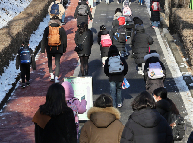 지난 7일 오전 서울 한 초등학교에서 학부모들이 아이들이 등교하는 모습을 보고 있다. /연합뉴스