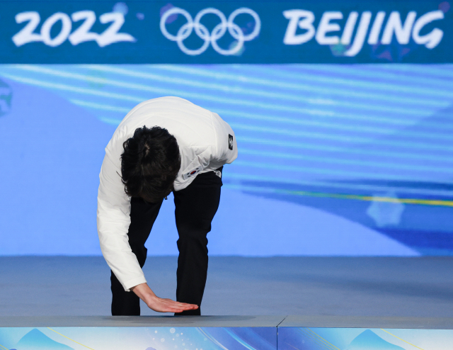 2022 베이징 동계올림픽 스피드스케이팅 남자 500m에서 2위로 은메달을 획득한 차민규가 지난 12일 오후 중국 베이징 메달플라자에서 열린 메달수여식에서 이름이 호명된 뒤 시상에 올라가기 전 시상대 바닥을 손으로 쓸고 있다. /연합뉴스